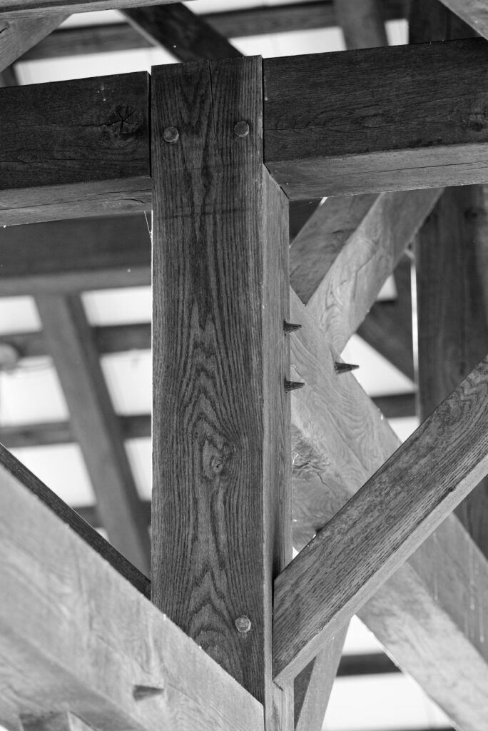 Black and white close-up of wooden beam construction joinery reflecting rustic architecture.